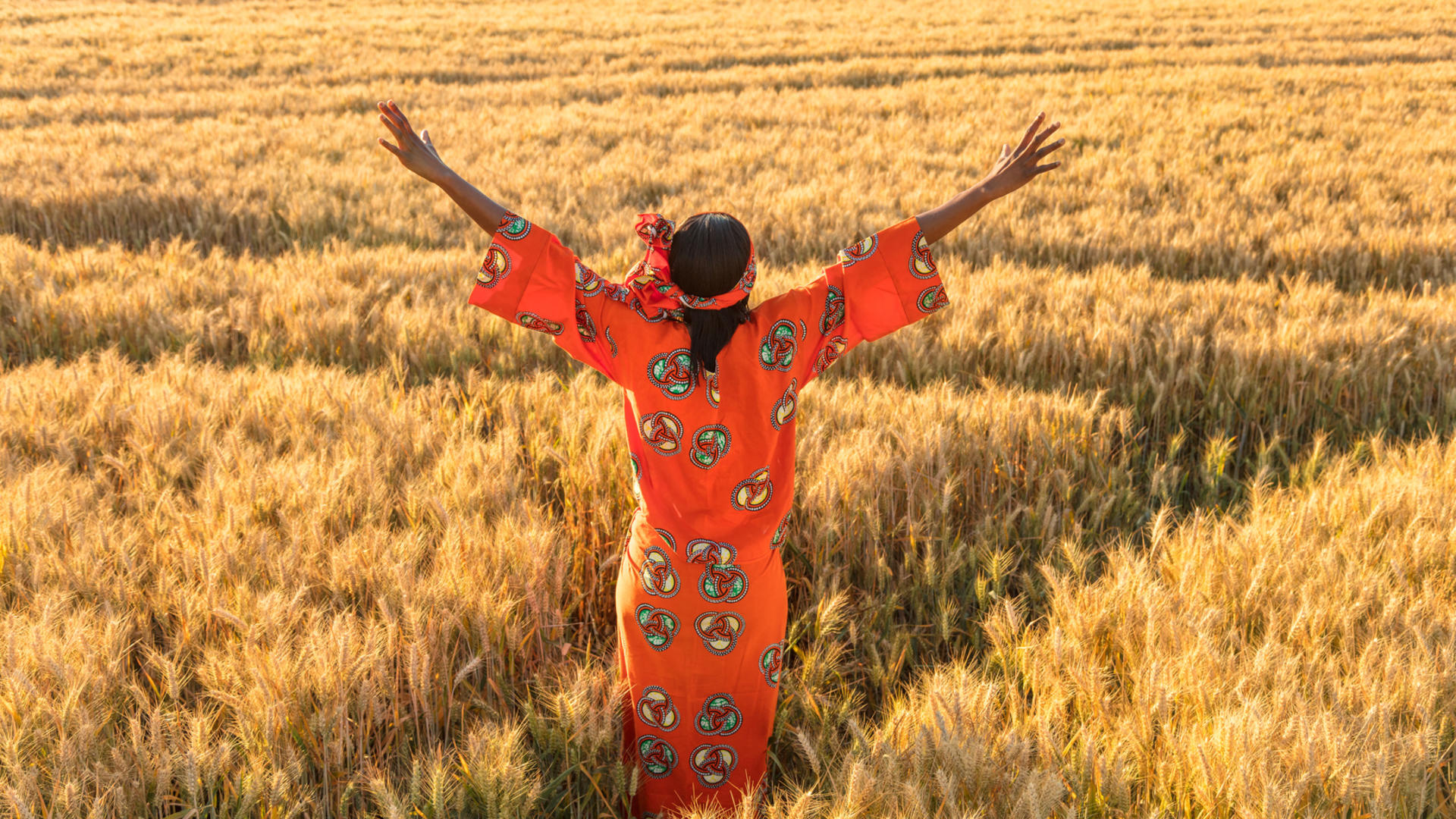 Africaine en habit traditionnel dans un champ de blé