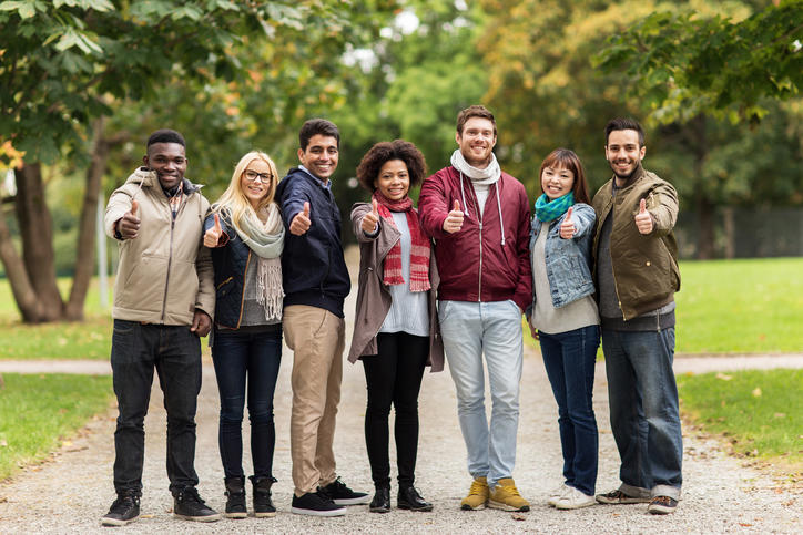 Groupe de jeunes pouces levés dans un jardin public