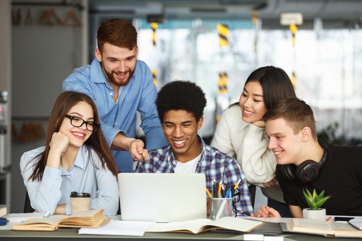 Un groupe d'étudiants consultent un site de candidature en ligne